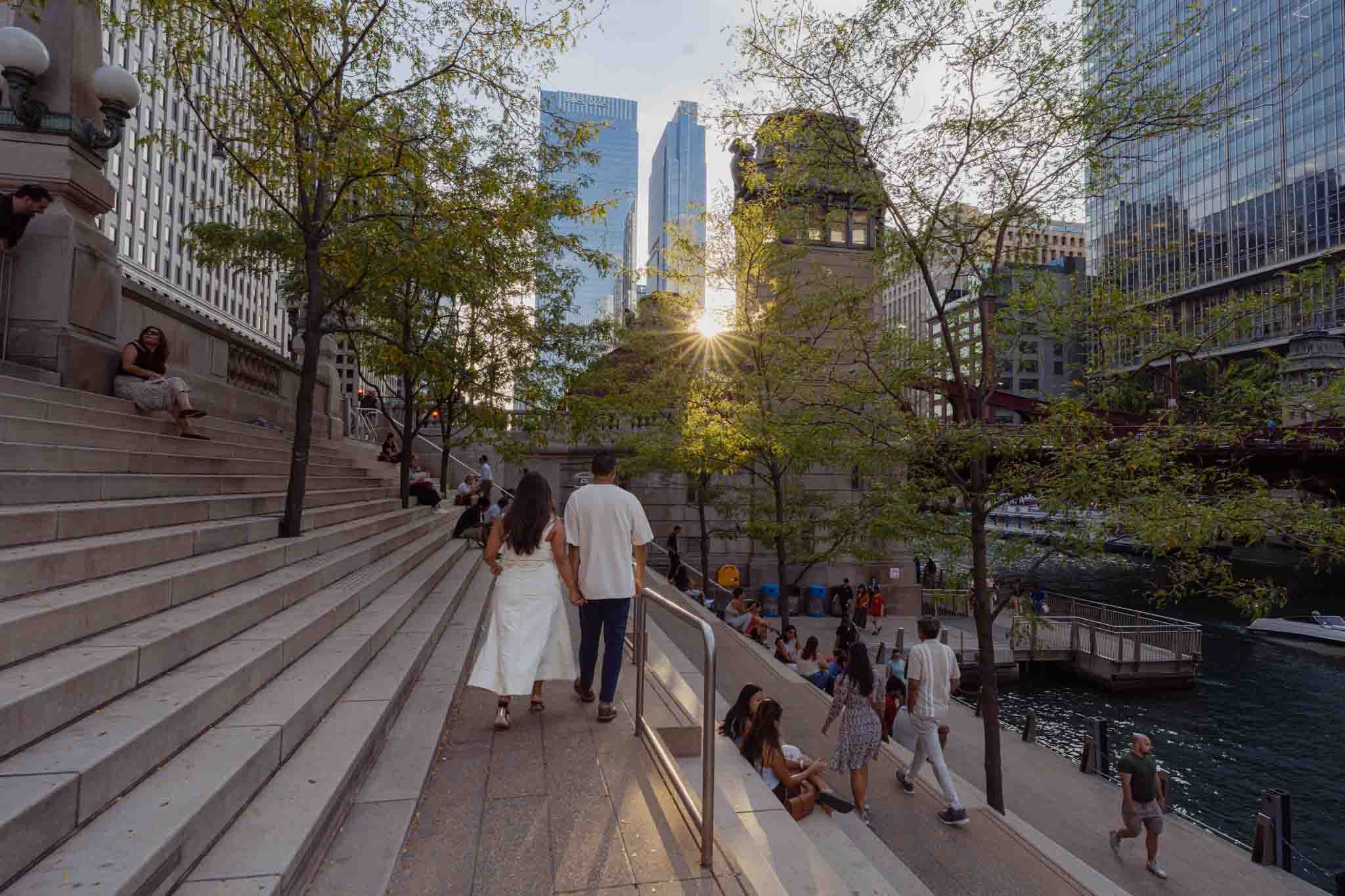 Alexis and Jason walking hand in hand down the Chicago Riverwalk steps