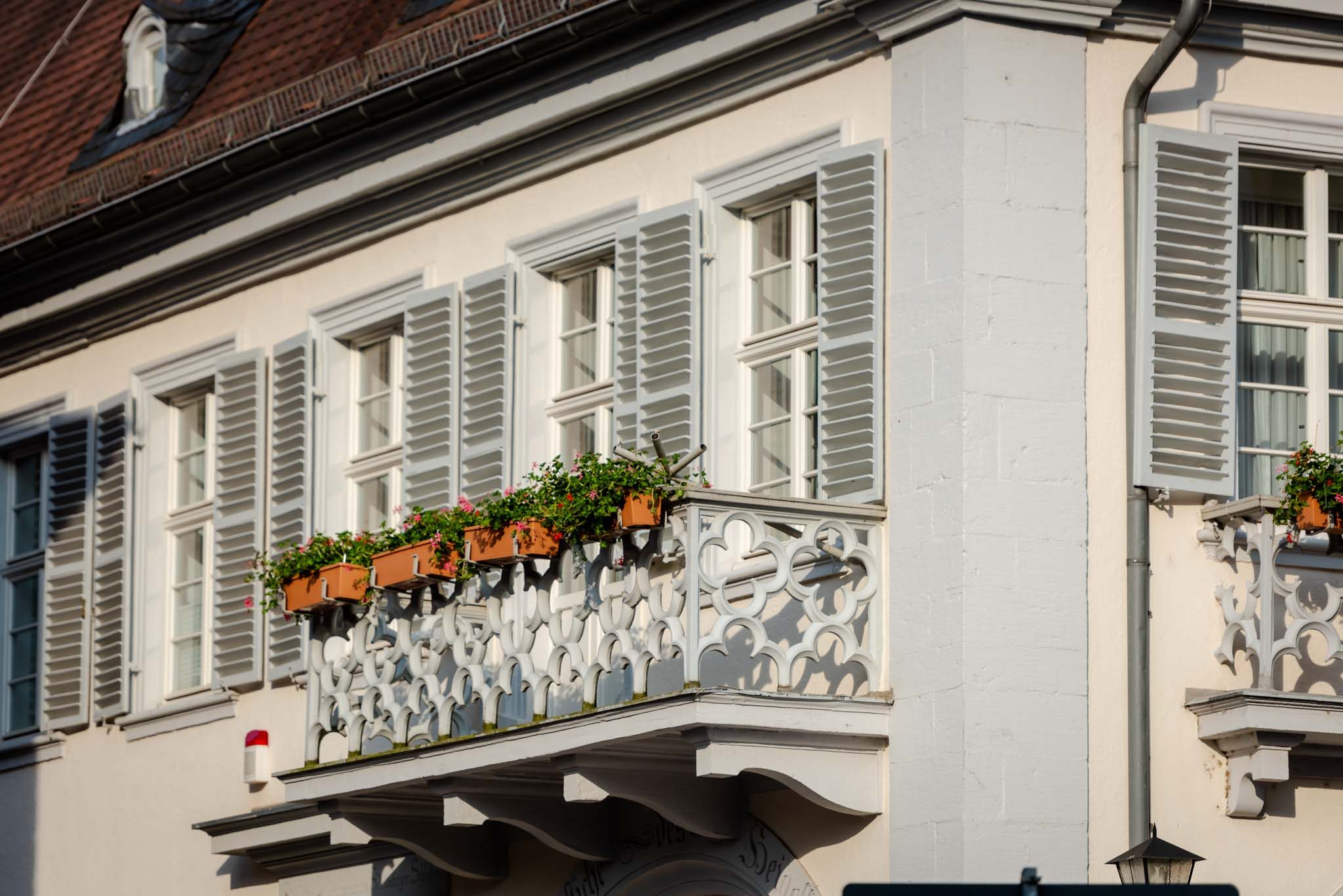 Flower boxes along a white wrought-iron balcony in Heidelberg