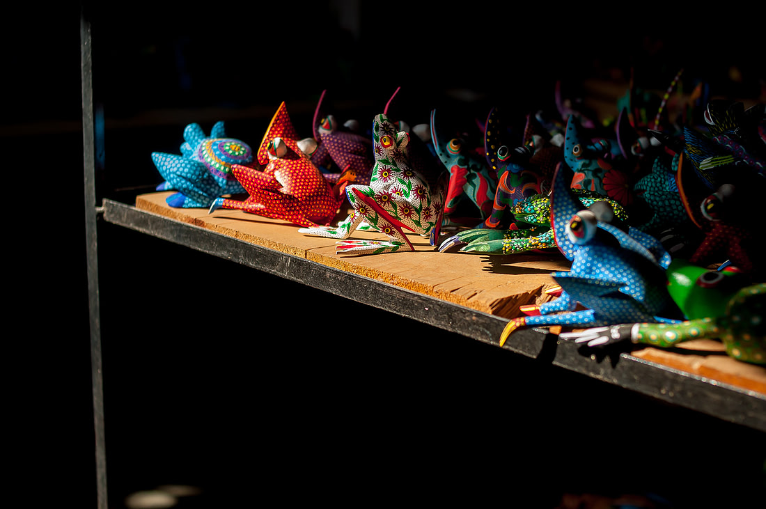 A row of hand-carved, brightly painted wooden alebrijes figures