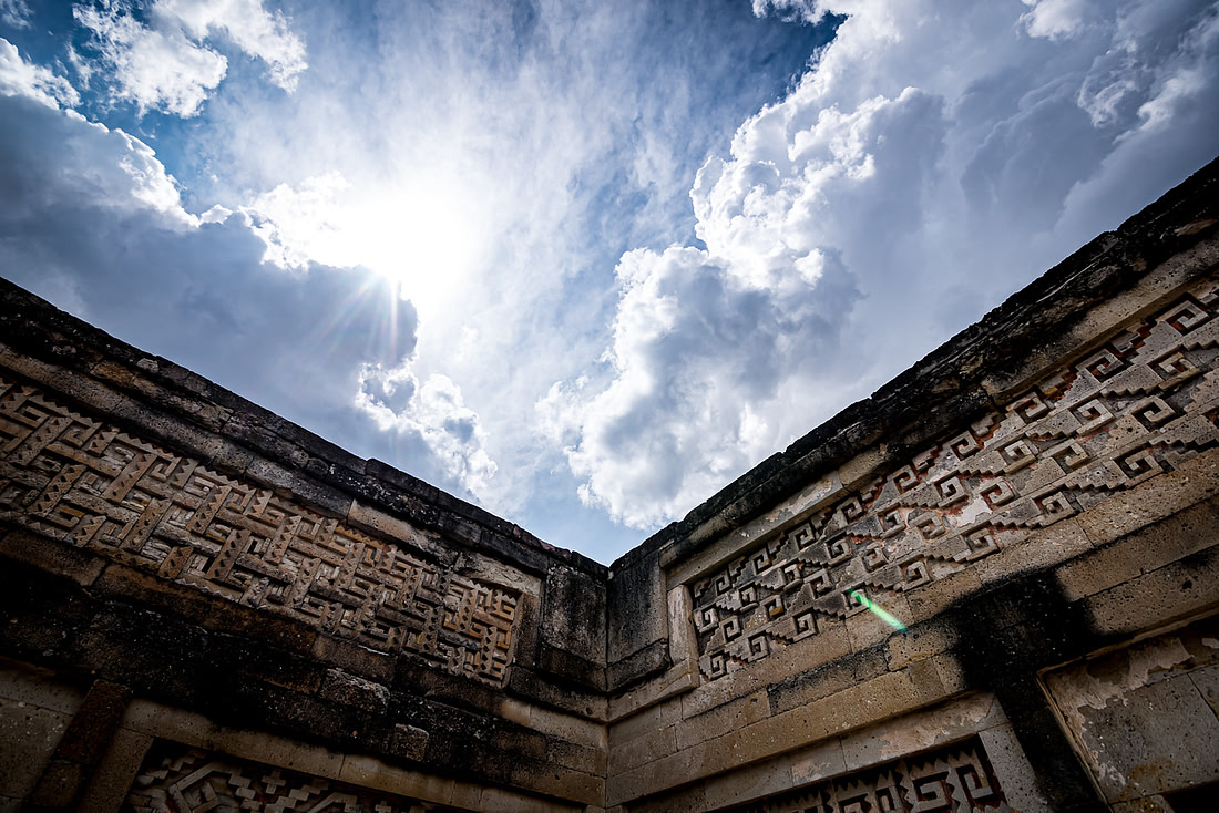 Close-up of Mitla’s fitted stone mosaic frieze work against a stormy sky
