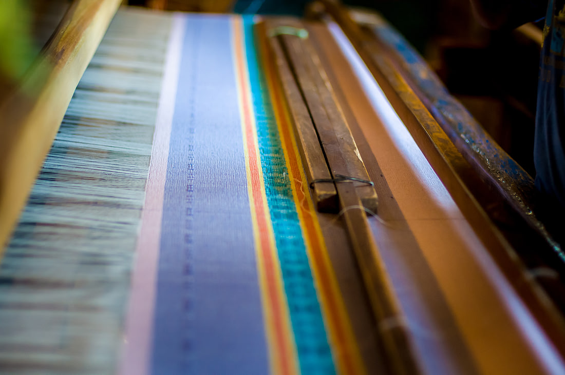 Colorful threads strung on a wooden loom, mid-weave, Teotitlán del Valle