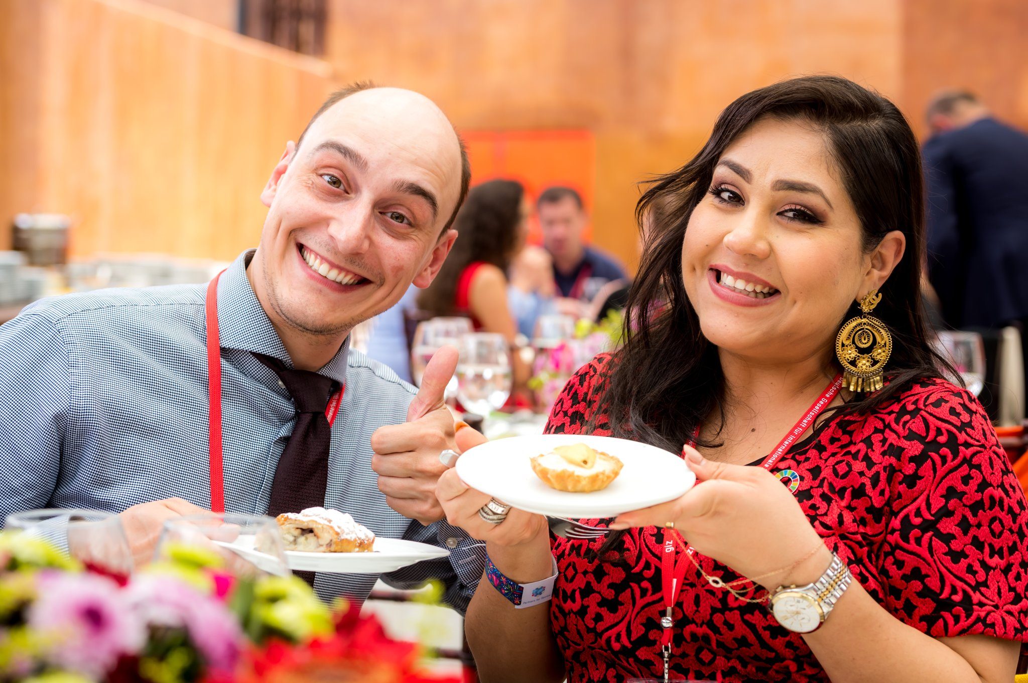 Conference guests laughing over dessert