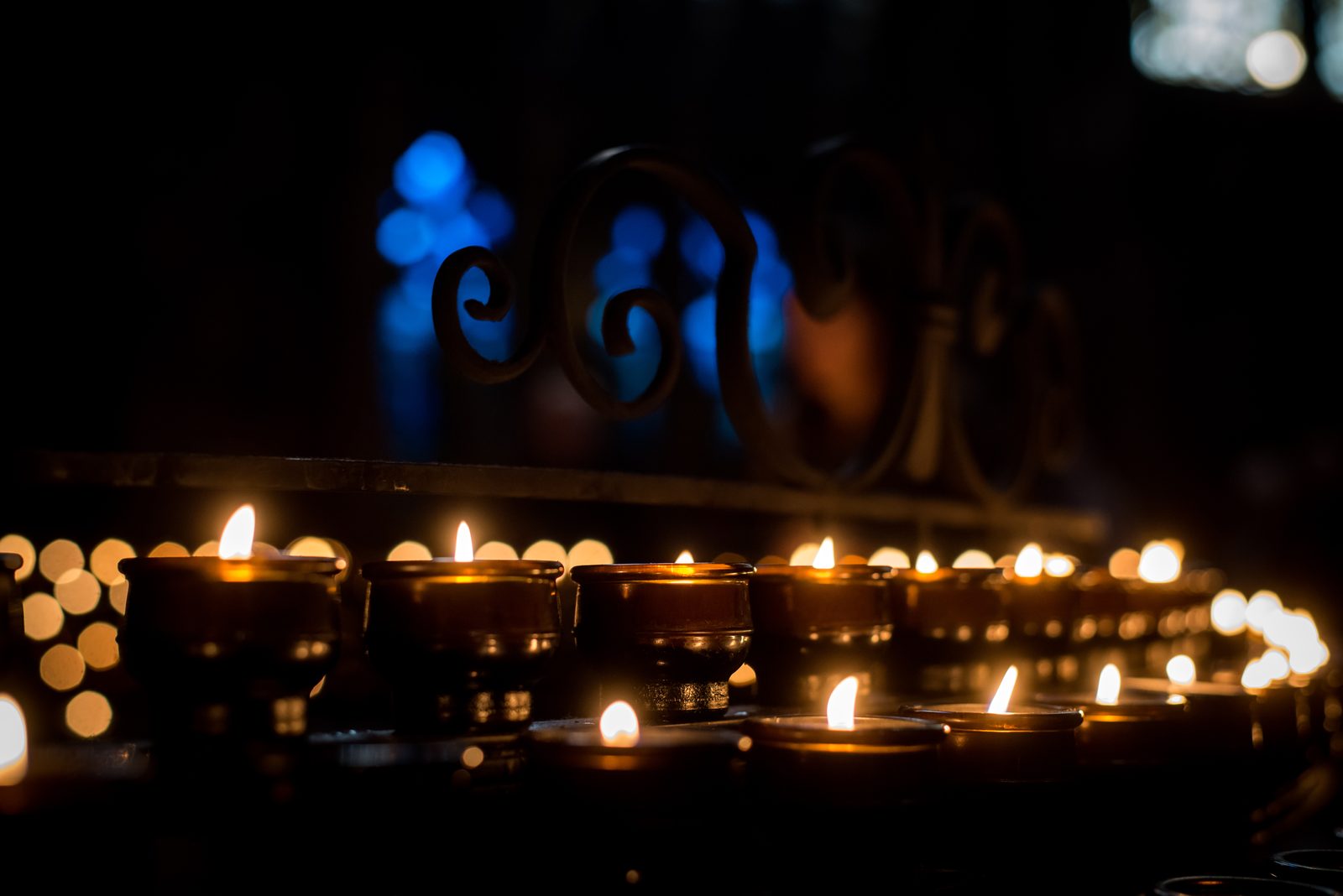 Rows of candles burning in the dark inside Freiburg Minster