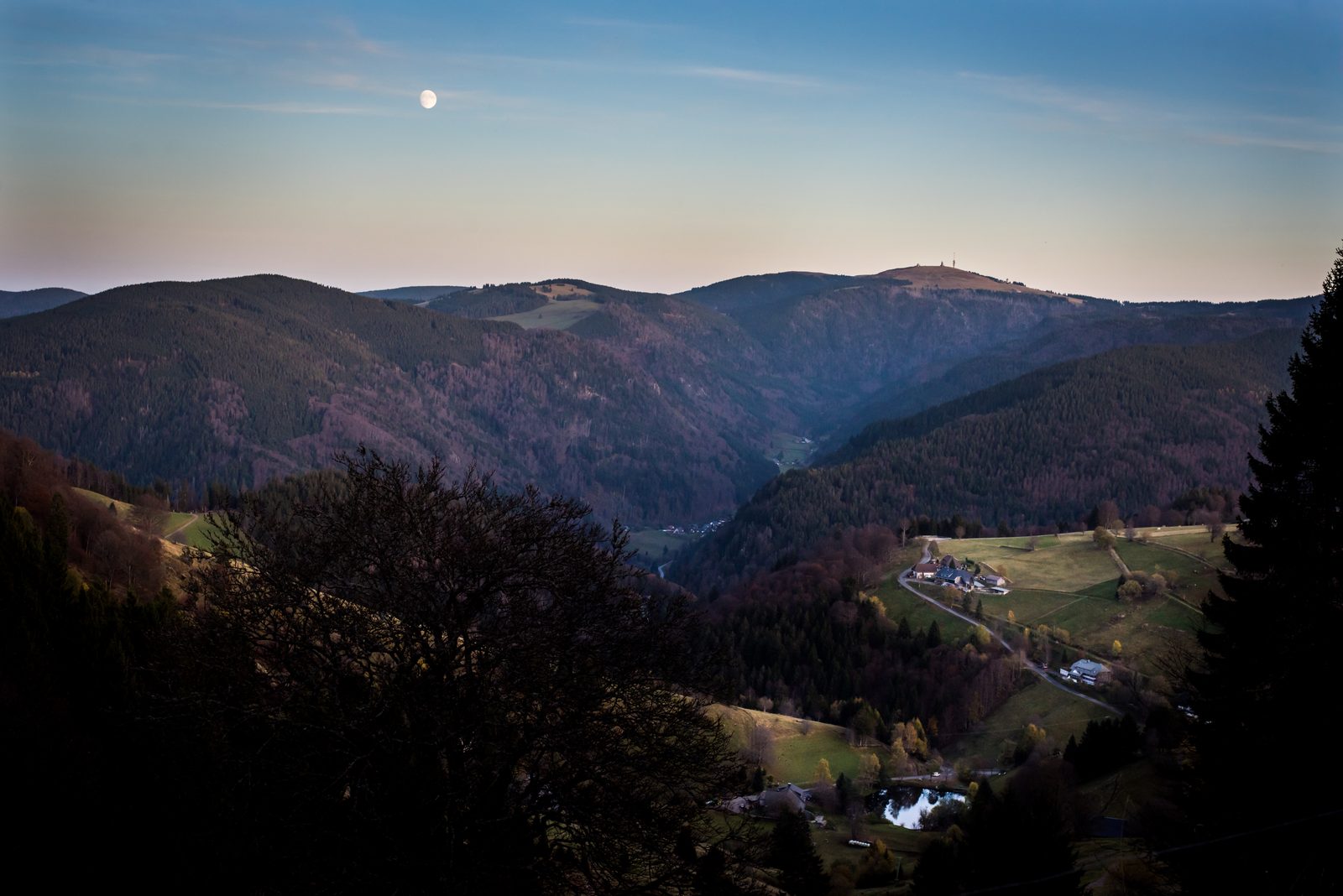 The moon over a Black Forest valley at dusk