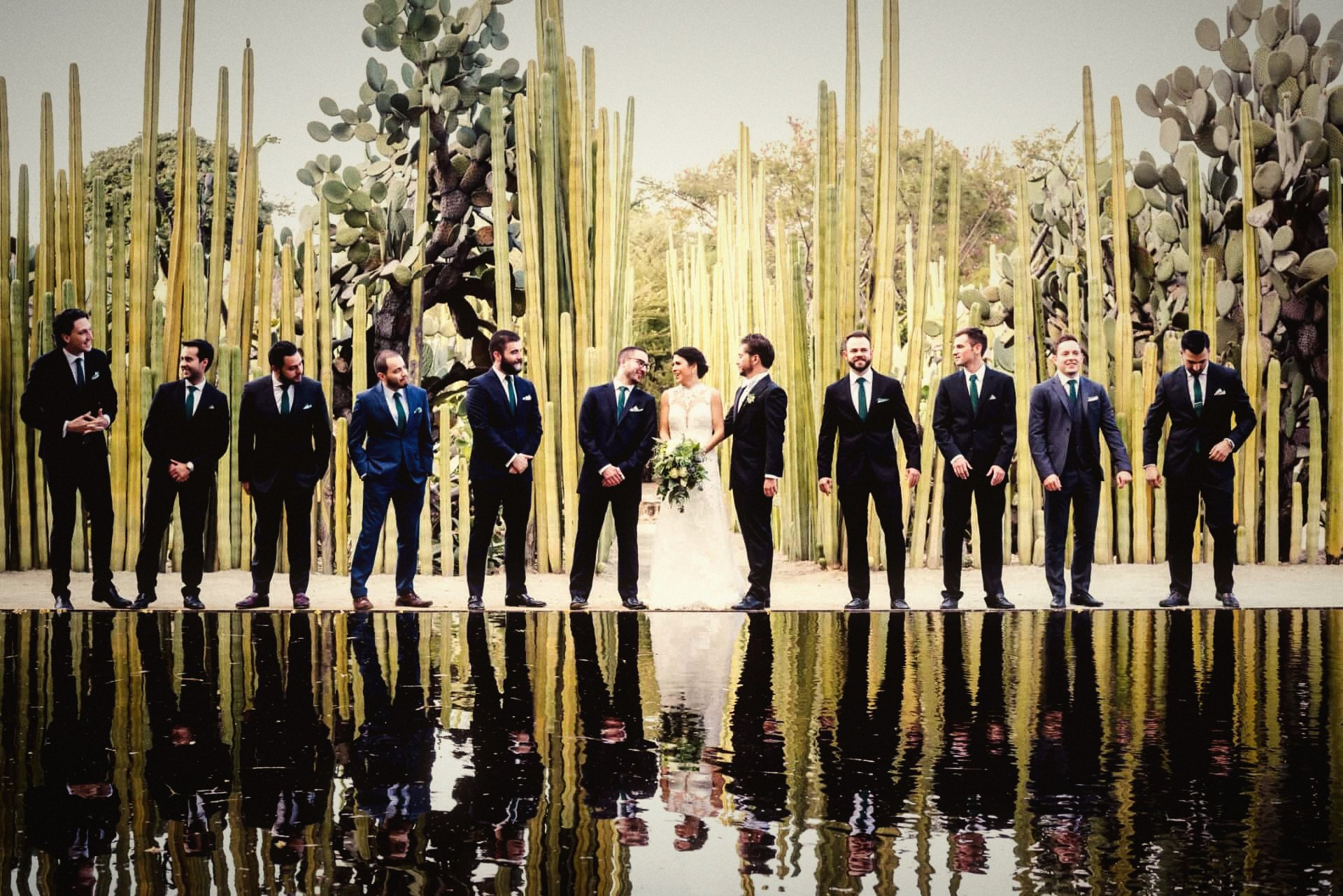 Wedding party reflected in the water at the cactus wall, Jardín Etnobotánico