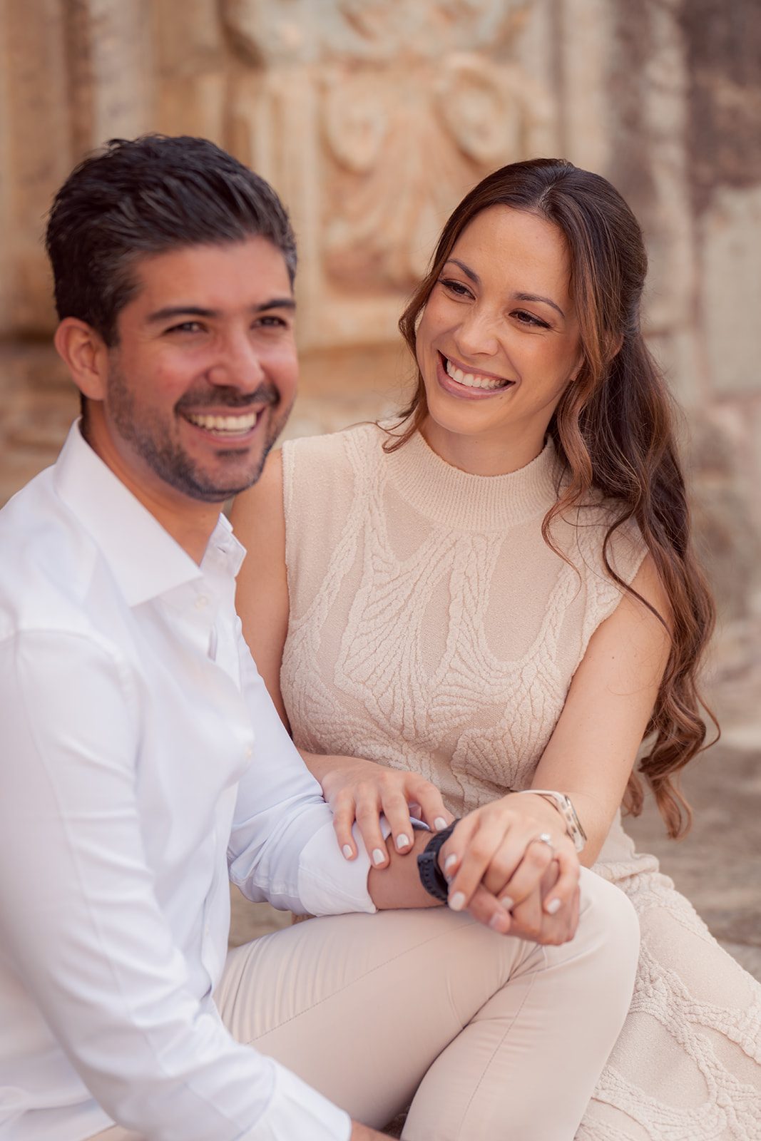 Mariana and Eduardo laughing on the steps of an old church door