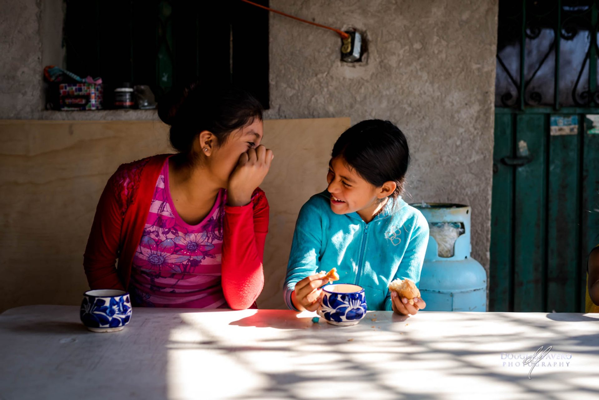 Two girls laughing at a table