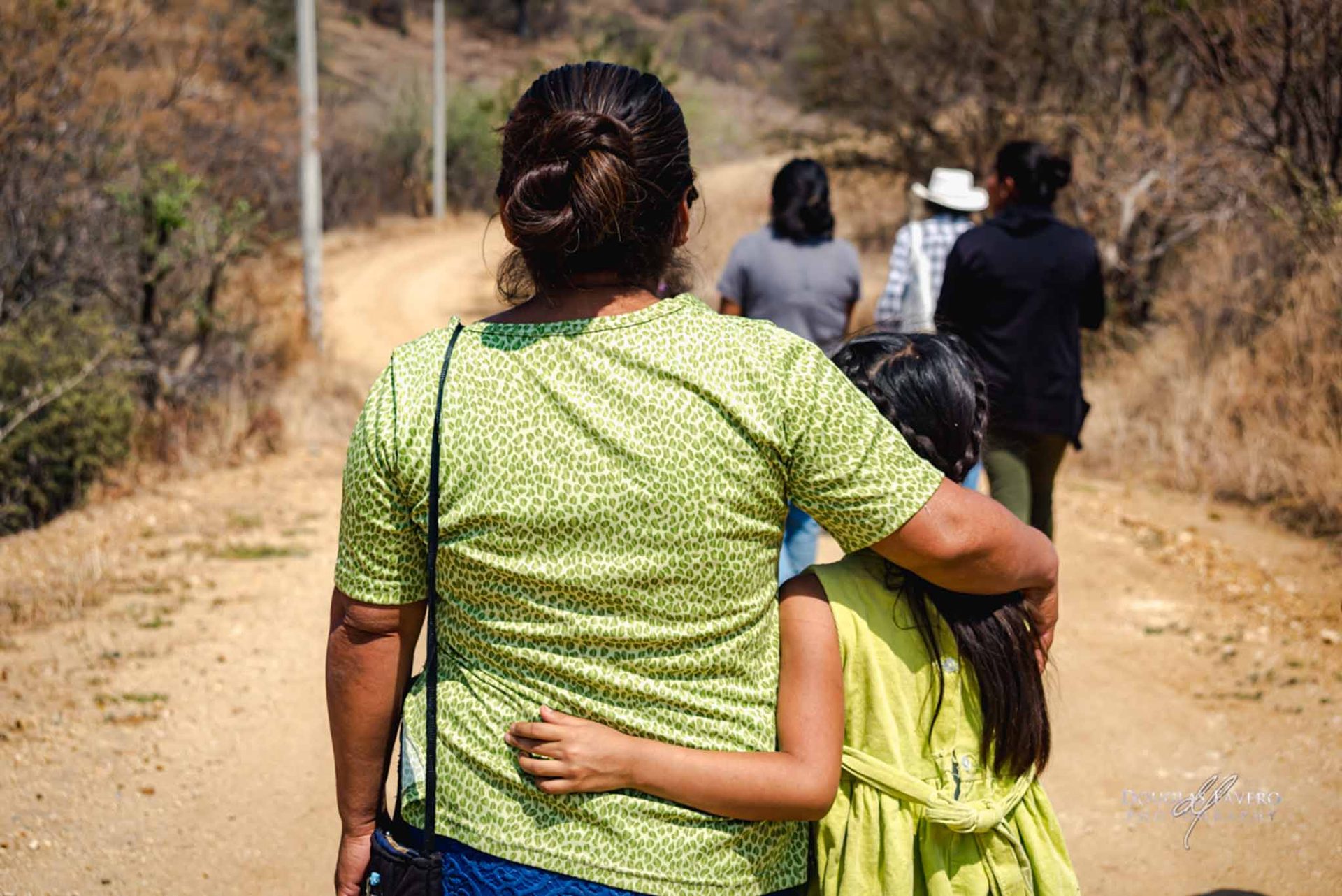A mother and daughter walking arm in arm outside Zaachila