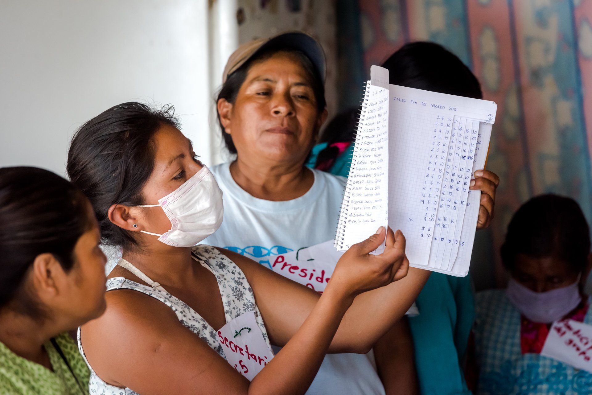 Women reviewing a list at a community meeting