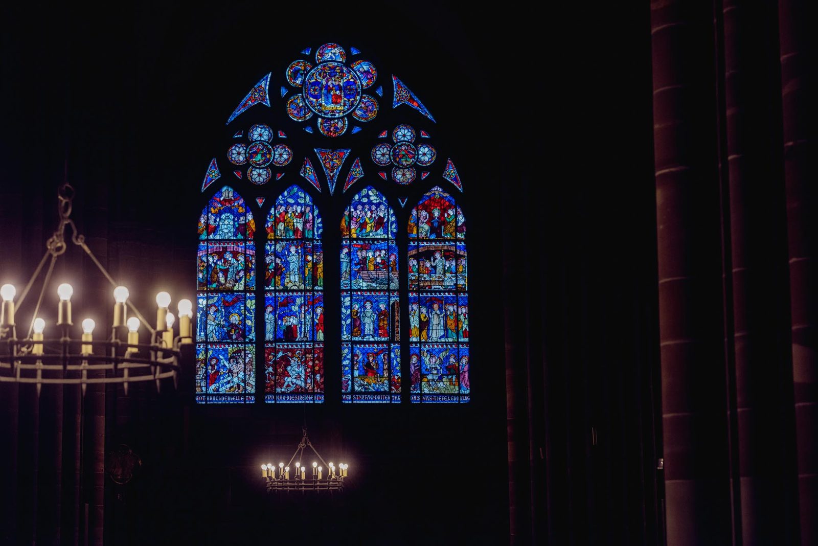 A stained-glass window glowing blue inside Strasbourg Cathedral